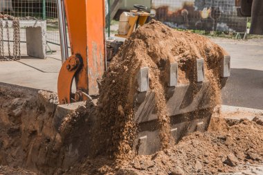 Kazı işe yarıyor. İnşaat alanında yerde ağır bir kürekle kamyon kazısı..