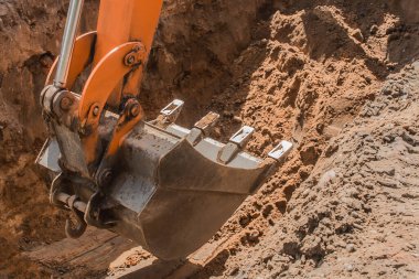 Kazı işe yarıyor. İnşaat alanında yerde ağır bir kürekle kamyon kazısı..