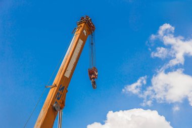Makinenin halat çeliği ile kaldırma mekanizması demir kablo ile vinç ve mavi gökyüzü arka planı kanca.