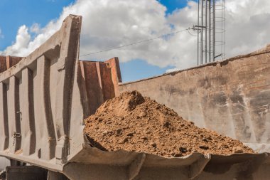 Arkasında kum yığını olan çöp kamyonu inşaat alanında toprak işçiliğini yıkadı..