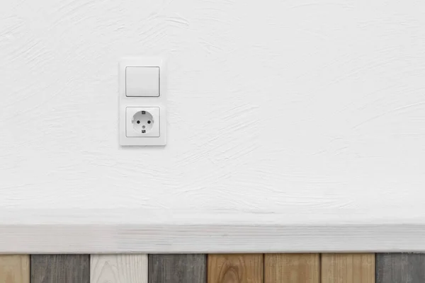 Socket and light off turn on button on the background of the switch white wall modern interior of the house.