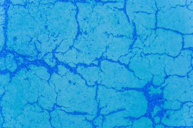Mavi boya beton yüzeyindeki çatlaklar yıpranmış çimentoyu çatlatmış, aşınmış doku soyut hasar görmüş arka plan..