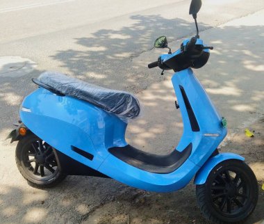 Bangalore 'da yol kenarına park edilmiş mavi Ola elektrikli scooter fotoğrafı.