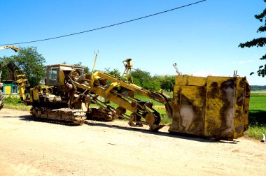 Kazıcı boru döşeme için bir siper kazıyor