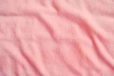Yumuşak yumuşak pastel pembe kumaş, dalgalı ve kıvrımlı. Yumuşak pastel tekstil dokusu. Soyut arkaplan.
