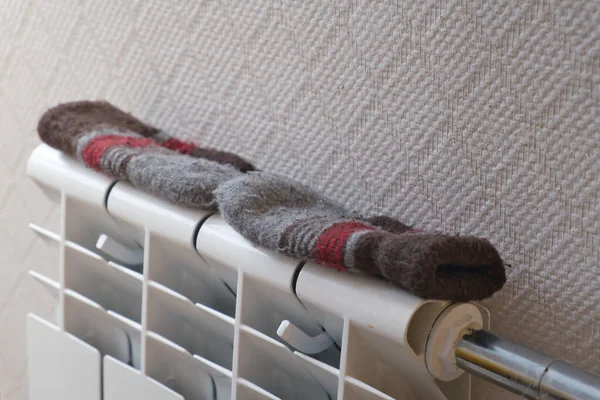 Par de manoplas de lana para niños en el radiador de calefacción en casa. — Foto de Stock
