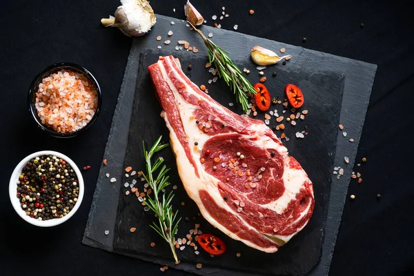 Rauwe Biefstuk Met Specerijen Kruiden Zwarte Achtergrond Zout Peper Knoflook — Stockfoto