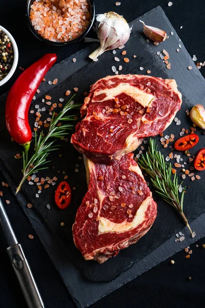 Rauwe Biefstuk Met Specerijen Kruiden Zwarte Achtergrond Zout Peper Knoflook — Stockfoto