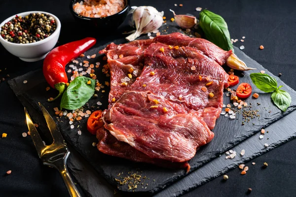 Rauwe Biefstuk Met Specerijen Kruiden Zwarte Achtergrond Zout Peper Knoflook — Stockfoto