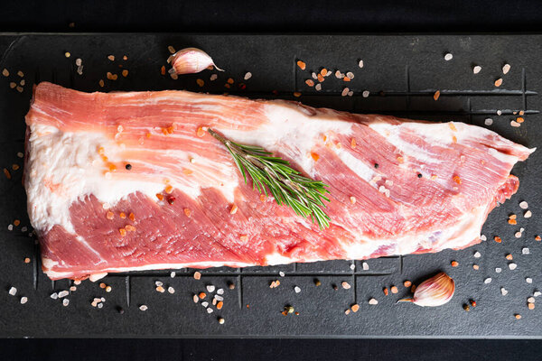Pork meat on a board, premium cut ribs, on dark background with spices