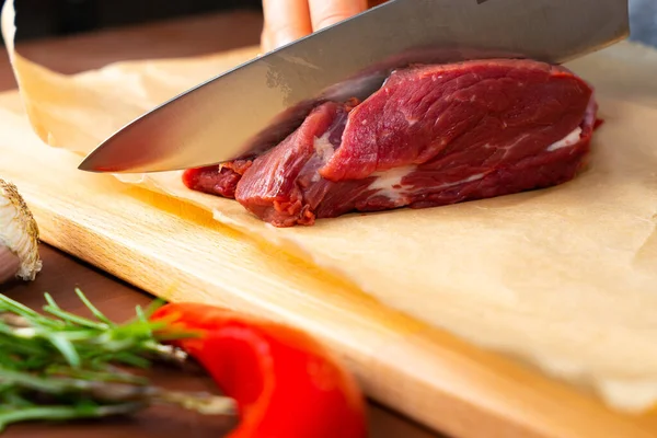 Frauenhände Schneiden Rohes Rindfleisch Gewürze Und Rosmarin Auf Einem Holzschneidebrett — Stockfoto