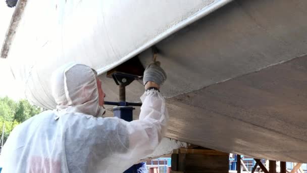 Il lavoratore dipinge il metallo di vecchia elica di nave arrugginita a cantiere navale in porto . — Video Stock