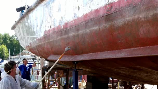 Werknemer verven metaal van oude roestige schip propeller op scheepswerf in haven. — Stockvideo