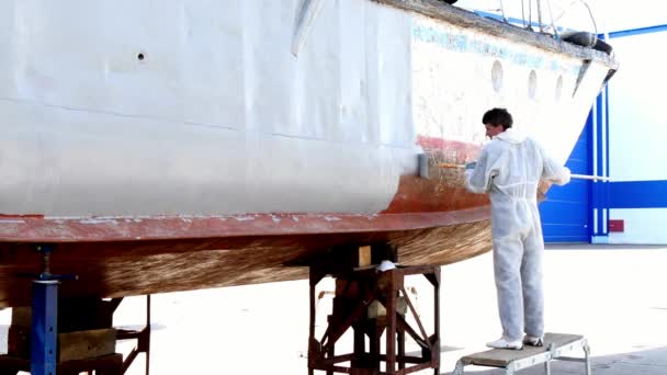 Werknemer verven metaal van oude roestige schip propeller op scheepswerf in haven. — Stockvideo