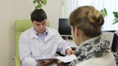 Aile doktoru hasta tansiyon ölçer.