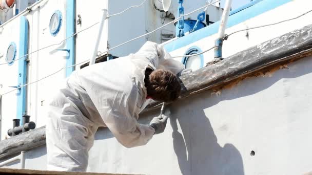 Εργαζόμενος χρωματίζει με βούρτσα μέταλλο μπροστά από το πλοίο στο ναυπηγείο στο λιμάνι της Μόσχας. — Αρχείο Βίντεο