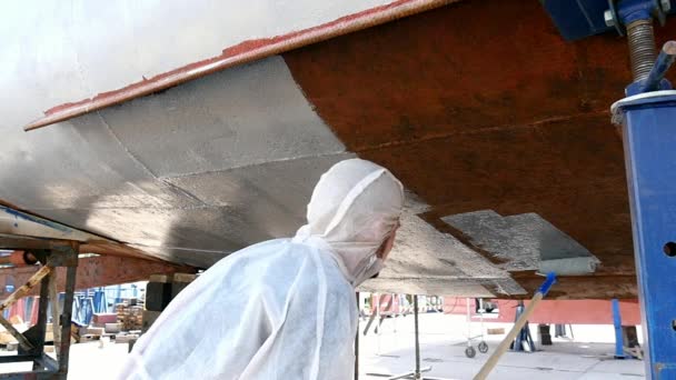 Trabalhador pinta com escova de metal frente de navio no estaleiro no porto de Moscou . — Vídeo de Stock