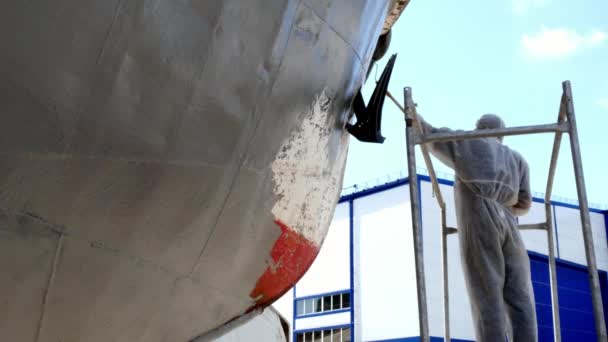 Trabajador pinta metal de vieja hélice de barco oxidado en astillero en puerto . — Vídeo de stock