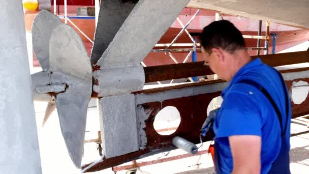 古い錆びた船プロペラには、ポートの造船所の労働者塗料金属. — ストック動画