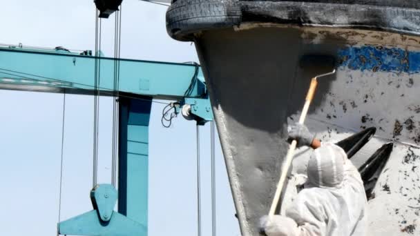 Працівник малює метал старого іржавого корабельного гвинта на верфі в порту . — стокове відео