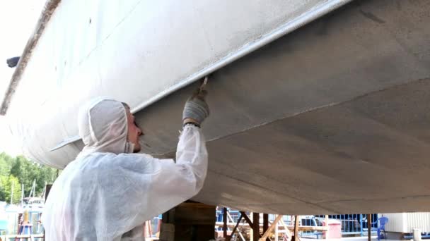 Arbetaren målar metall av gammal rostig fartyget propeller på varvet i hamn. — Stockvideo