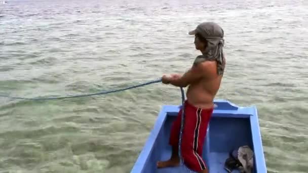 Les gens montent sur un bateau philippin avec des ailes de bambou en mer aux Philippines. — Video