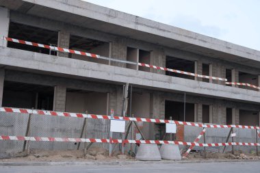 Tamamlanmamış apartman inşaatı uyarısıyla devam ediyor. İnşaat alanı.