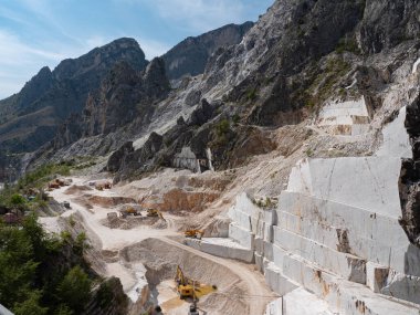 Kazı araçlarının çalışmaya hazır olduğu Carrara mermer ocaklarının görüntüsü.