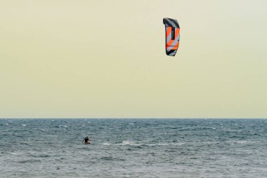 Çok dalgalı bir denizle rüzgarlı bir günde uçurtma uçurmak.