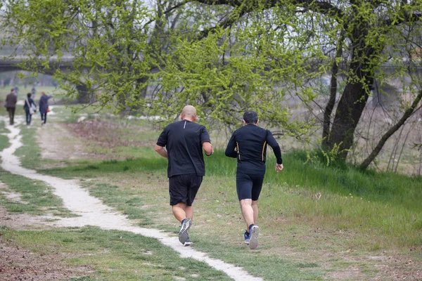 Two Middle Aged Men Jogging Banks River Bridge Background — Zdjęcie stockowe