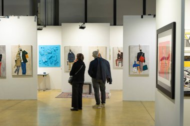 Buyers Evaluating the Purchase of Works in a Modern Art Gallery.