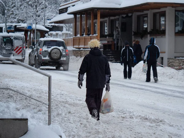 Skidåkare Skiddräkter Går Nerför Snöfylld Gata Med Shoppingväskor Teir Händerna — Stockfoto