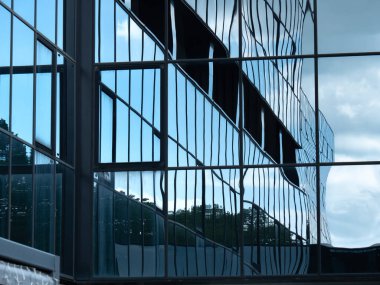 Mavi gökyüzü ve bulutlar cam binada yansıyan