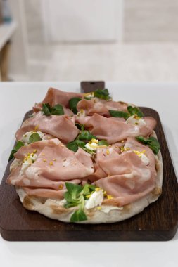 Salamlı, fesleğenli ve peynirli pizza..