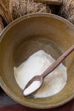 İçinde biraz un ve uzun tahta kaşık ve buğday olan büyük bir kase..