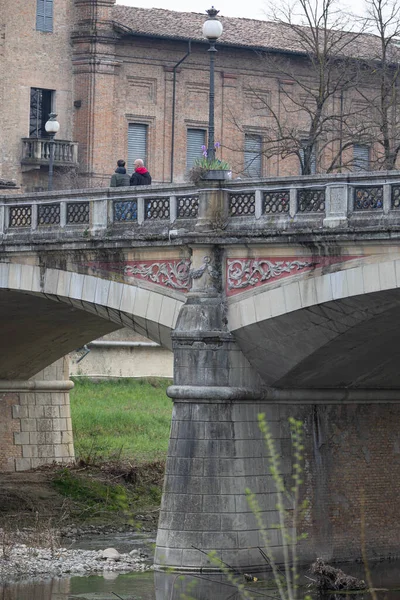 Men Walking on the Bridge in the center of Parma on a Spring Day, Italy.