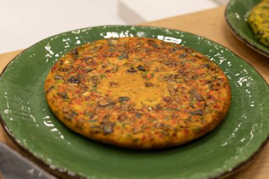 Appetizing Omelet-like Vegetable Pie in a Green Dish.