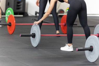 Spor salonunda beden eğitimi: Sınıfta halterle egzersiz yapan kızlar.