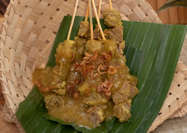 Sate Padang或Satay Padang是西苏门答腊岛Padang的辣牛肉沙袋 配上辣咖喱酱和米糕 在香蕉叶上悠长 — 图库照片