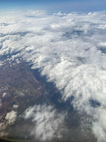 地面の上の雲 飛行機の窓からの雲と地面 — ストック写真