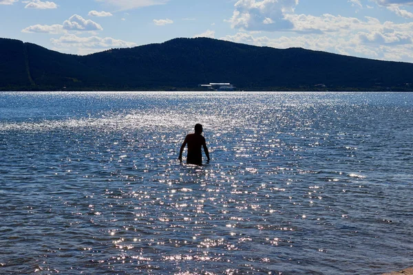 夏に湖で日光浴をする男のシルエット — ストック写真