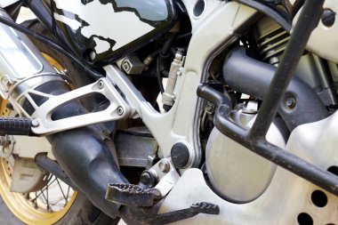 Pedallı ve motorlu bir motosikletin yan görüntüsü. 