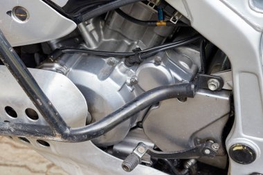 Pedallı ve motorlu bir motosikletin yan görüntüsü. 