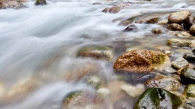Kayaların üzerinden akan bir dağ nehri. Bulanık hareket arkaplan fotoğrafı
