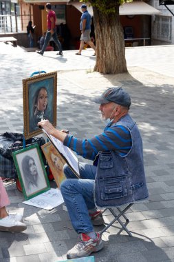 Almaty, Kazakistan 20 Haziran 2021: kaldırıma bir portre çizen sokak sanatçısı 