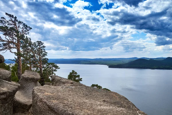 Kazakistan 'daki Burabay Ulusal Parkı' nda ormanla kaplı göl ve dağların manzarası.