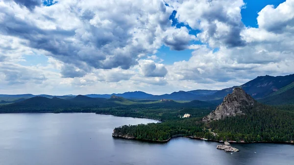 Burabay Ulusal Parkı, Kazakistan 'da dramatik bulutların, göl ve dağların panoramik manzarası ormanla kaplıdır.