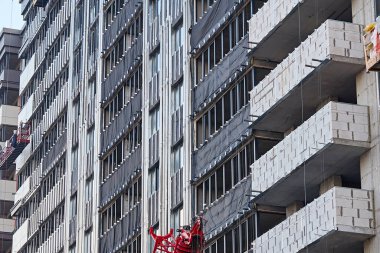 Mavi gökyüzünün arka planında bulutlu, modern çok katlı bir bina. Almaty, Kazakistan - 21 Ekim 2021