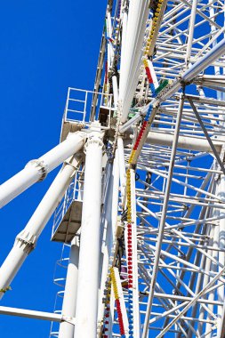 Mavi gökyüzüne karşı dönme dolabın çelik yapısının alt görüntüsü