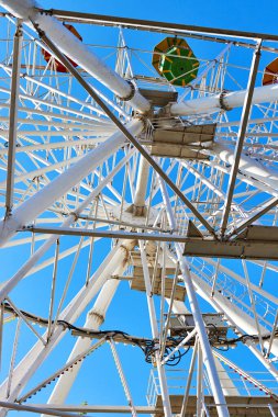 Mavi gökyüzüne karşı dönme dolabın çelik yapısının alt görüntüsü